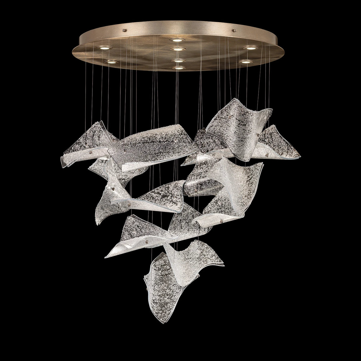 Chandelier with cascading curved textured clear glass panels and a round gold-toned ceiling canopy.