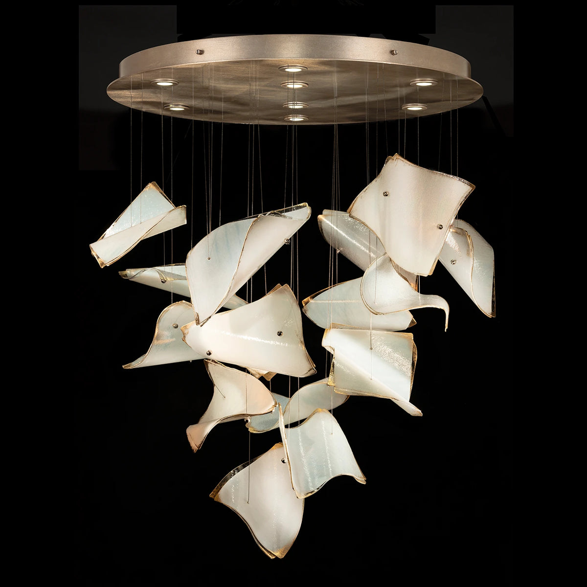Chandelier with cascading curved ivory glass panels, gold-toned edges and a round gold-toned ceiling canopy.