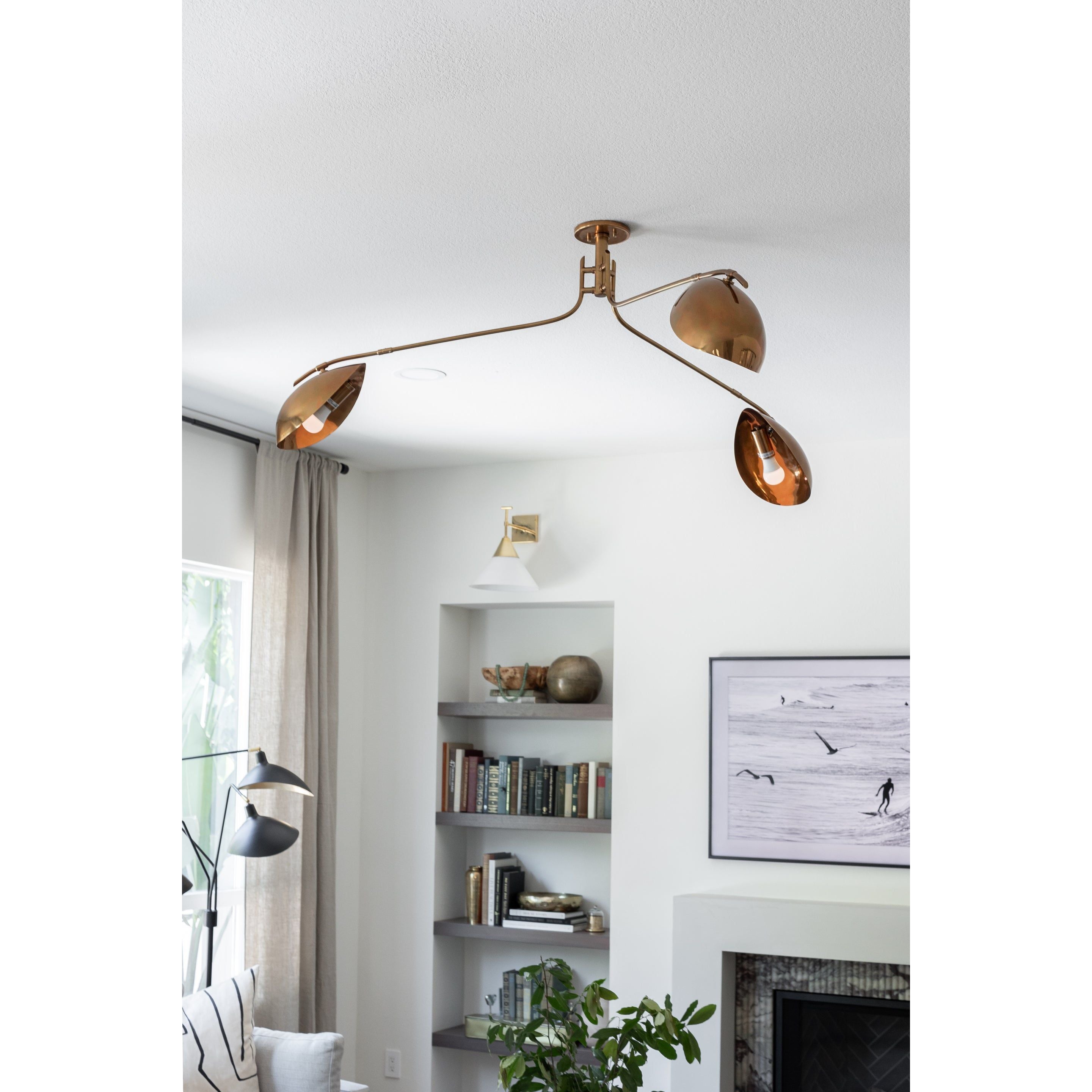 Avondale three-arm antique brass ceiling light with curved arms and bowl-shaped shades in modern living room