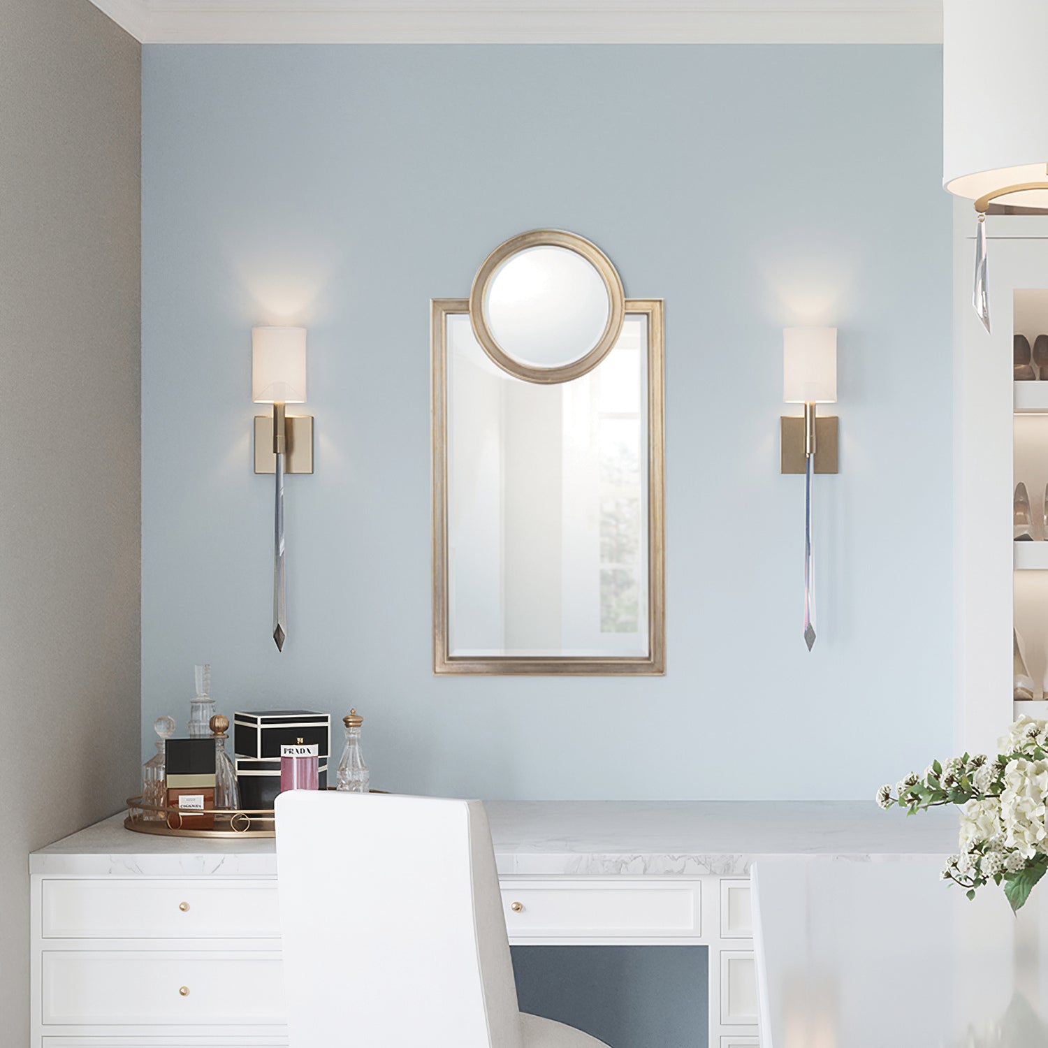 Elegant home office featuring modern wall sconces with soft ambient lighting, complementing a gold-framed mirror, white marble desk, and light blue walls.