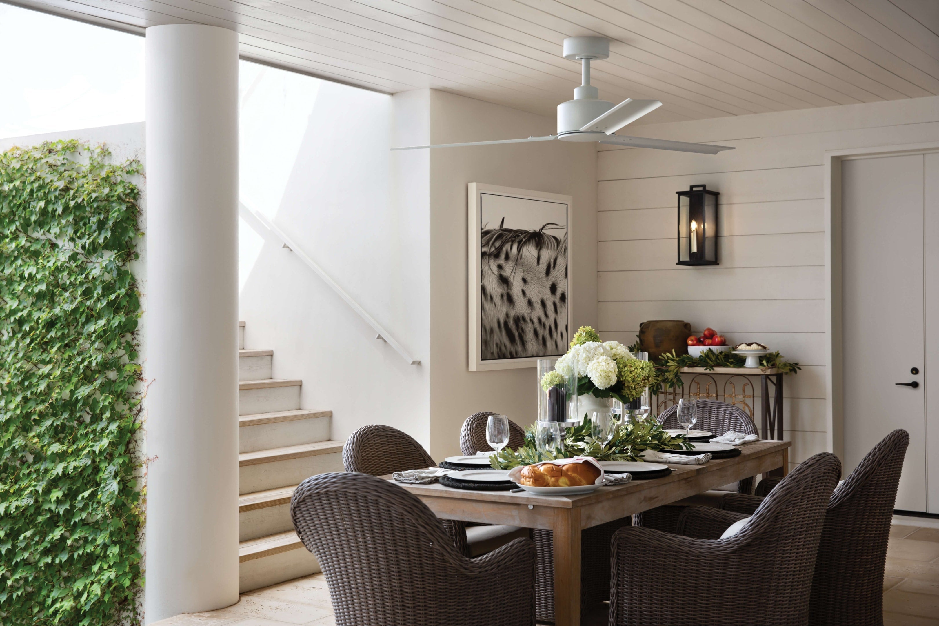 Outdoor dining space with a ceiling fan, showing which way should a ceiling fan spin in the summer vs winter for power efficiency.