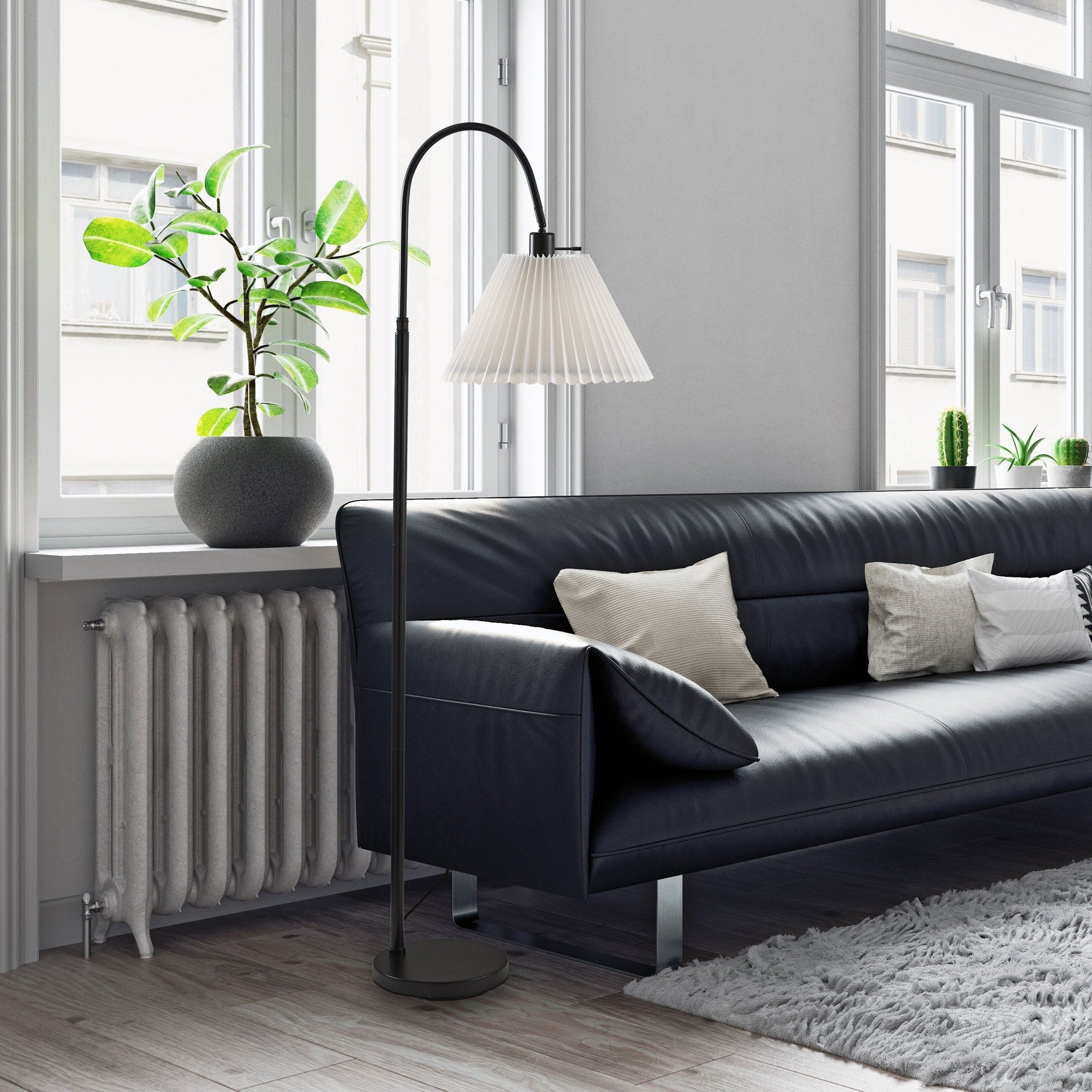 Floor Lamp black floor lamp with pleated white shade beside a modern sofa and bright windows.