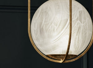 Alabaster lighting featuring a beautifully crafted glass globe suspended in a gold frame.