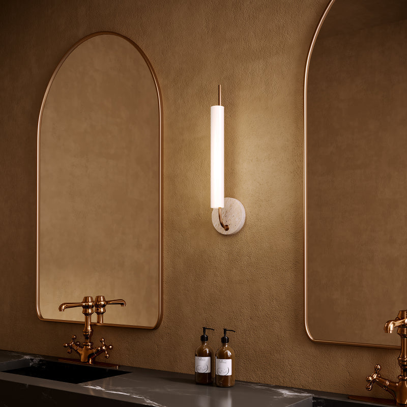 Bath Bars vertical LED bath bar with round stone backplate mounted between arched bathroom mirrors.