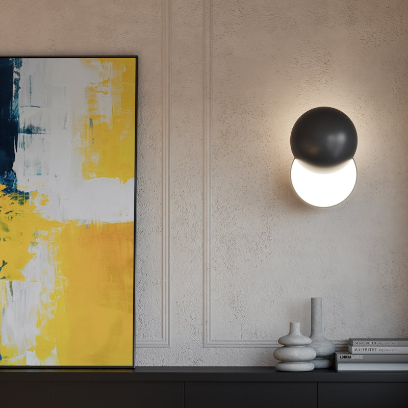 LED Wall Sconces modern LED wall sconce with black globe detail beside abstract artwork.