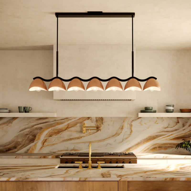 Linear Pendants black linear pendant with scalloped shades above a warm marble kitchen.