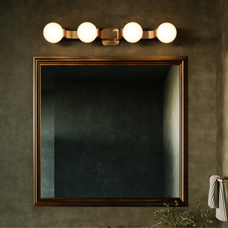 Modern Vanity Lights gold vanity light with glowing globe bulbs above a framed bathroom mirror.
