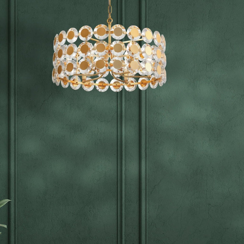 Chandeliers gold chandelier with crystal disc details against a dark green wall.