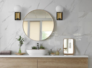 Modern bathroom lighting with globe sconces and gold accents, enhancing a stylish and minimalist vanity area.