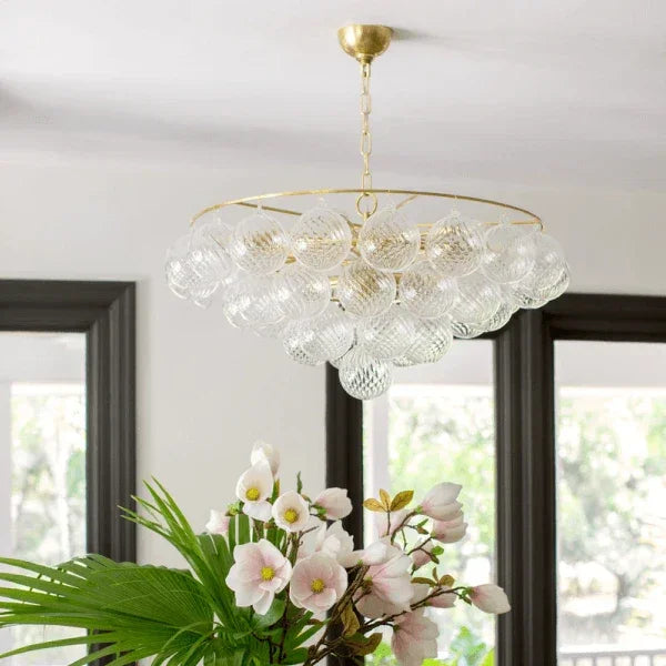 Mitzi chandelier with a cluster of textured glass globes and a gold frame, hanging in a dining room with floral decor, available at Lights Canada.