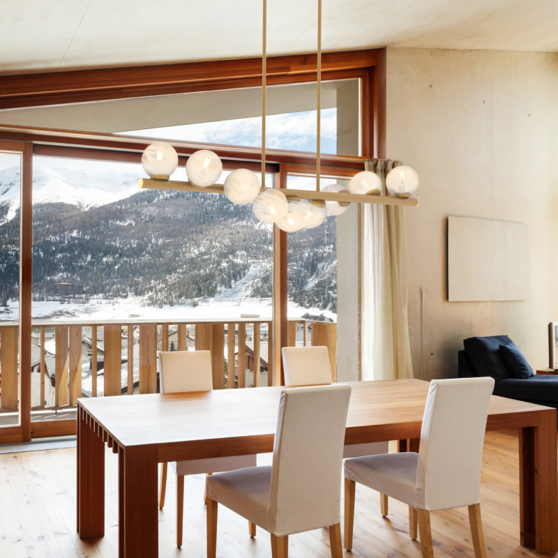 Contemporary Linear Lights contemporary gold linear light with globe shades above a dining table and mountain view.