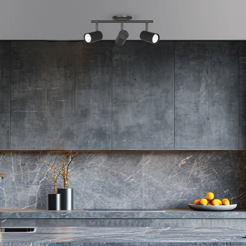 Track Lighting black three-light track fixture mounted above a modern grey kitchen with a marble backsplash.