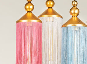 Bold and bright pendant lights with vibrant pink, white, and blue fringe shades and gold accents, adding a playful and colorful touch to any space.