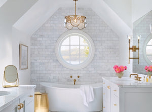 Hollywood Glam lighting in a luxurious bathroom with a gold chandelier and sconces, adding elegance and style to the space.