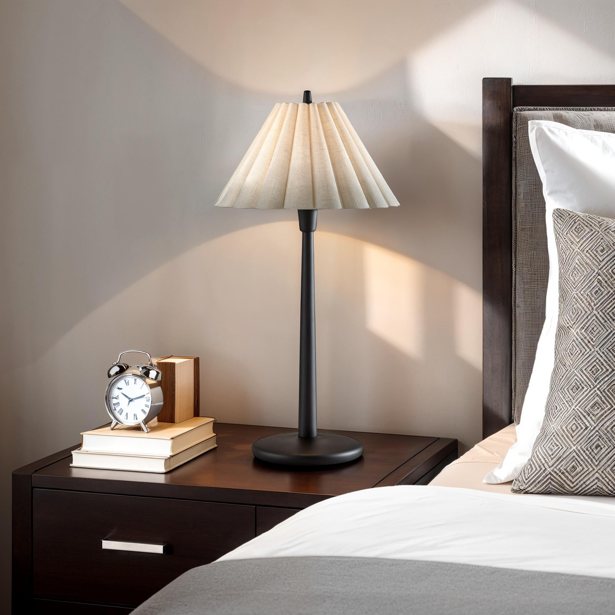 Table Lamp black table lamp with pleated fabric shade on a bedside table.