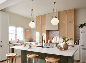 Kitchen lighting featuring modern globe pendant lights above a large island in a bright, minimalist kitchen with natural wood cabinets.