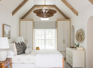 Bedroom lighting featuring a woven pendant light in a bright, airy room with vaulted ceilings and neutral decor.