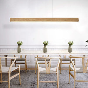 Modern dining room featuring a linear suspension light by Modern Forms, with a minimalist wooden design illuminating a large dining table.