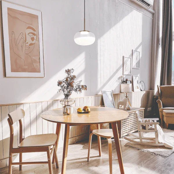 Modern dining room with pendant light by Matteo, illuminating a cozy, minimalist interior space with natural tones.