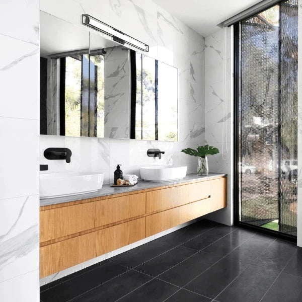 Contemporary bathroom featuring a sleek vanity light by Matteo, offering modern lighting above a large mirror and floating vanity.