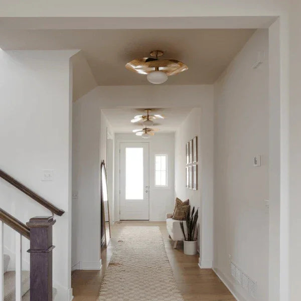 Modern hallway featuring flush mount lights by Mitzi, with brass accents and a sleek design, adding elegance to a bright interior space.
