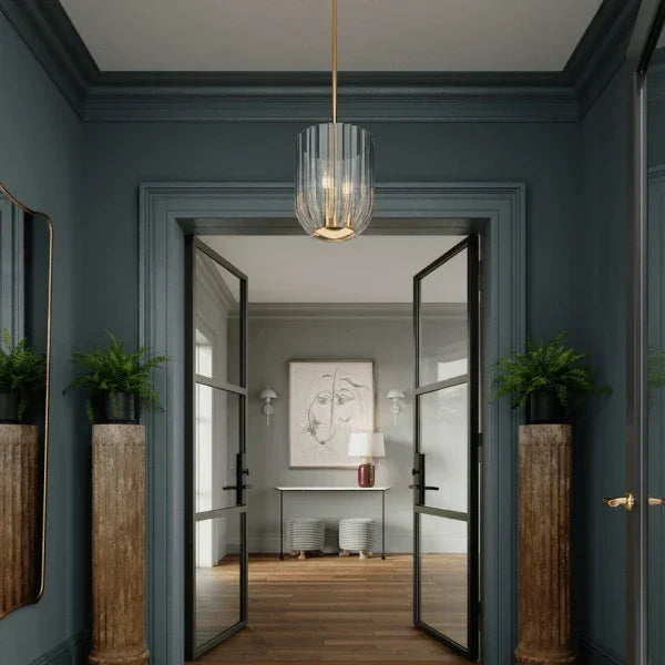 Stylish pendant light by Mitzi illuminating a modern entryway, featuring a glass shade and brass accents for a sophisticated design.