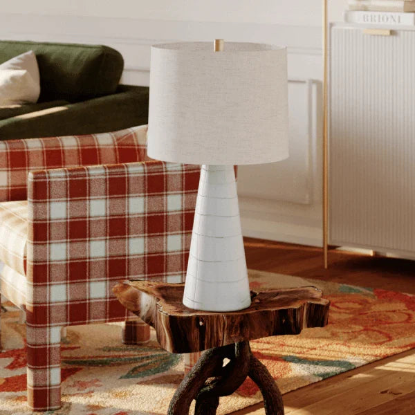 Modern table lamp by Mitzi with a tapered base and fabric shade, placed in a cozy living room.