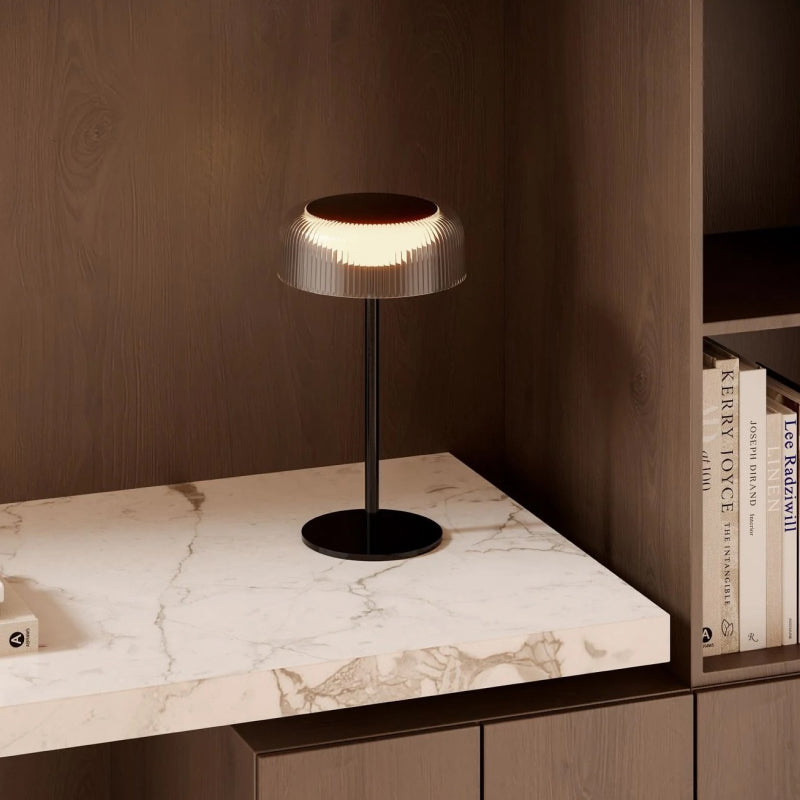 Rechargeable Lamp compact rechargeable table lamp with ribbed shade on a marble shelf.
