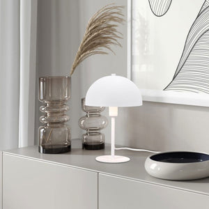 Modern table lamp by Trio Lighting with a dome-shaped shade, placed on a sleek console table.