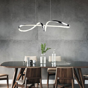 Modern sculptural linear pendant light by Trio Lighting above a dining table at Lights Canada