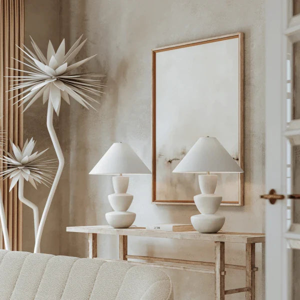 Modern ceramic table lamps by Troy with neutral shades placed on a console in an elegant living room.