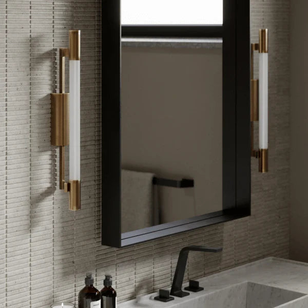 Modern brass and glass vanity lights by Troy mounted beside a bathroom mirror at Lights Canada