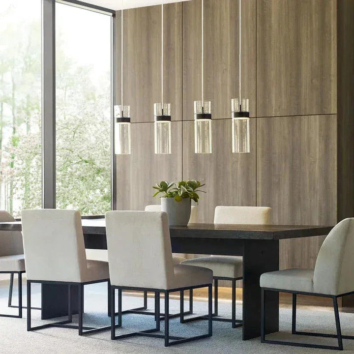 Pendant lights from the Visual Comfort Modern Collection, hanging over a modern dining table in a sleek, contemporary space.
