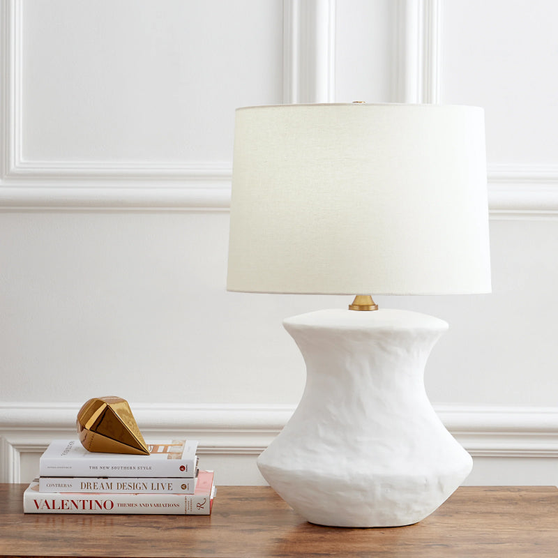 White Table Lamps white textured table lamp with a fabric drum shade on a wooden table.