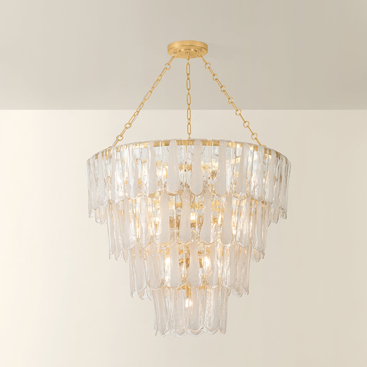 Tappan tiered crystal chandelier illuminated, with warm glow visible through layered rectangular glass panels on gold chain