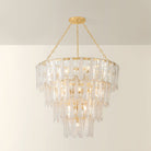 Tappan tiered crystal chandelier illuminated, with warm glow visible through layered rectangular glass panels on gold chain