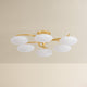 Six-arm chandelier with oval white glass globes on gold brass arms, unlit product shot