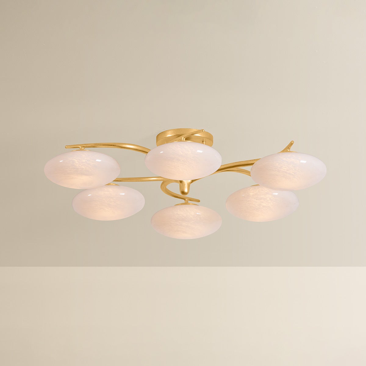 Six-arm chandelier with illuminated oval white glass globes on gold brass arms, product shot