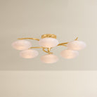 Six-arm chandelier with illuminated oval white glass globes on gold brass arms, product shot