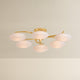 Six-arm chandelier with illuminated oval white glass globes on gold brass arms, product shot