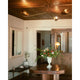 Avondale multi-arm ceiling light illuminated on wooden ceiling over entryway with floral arrangement on table