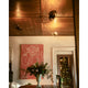 Avondale articulating arm ceiling light on wooden ceiling above stylish room with artwork and floral arrangement