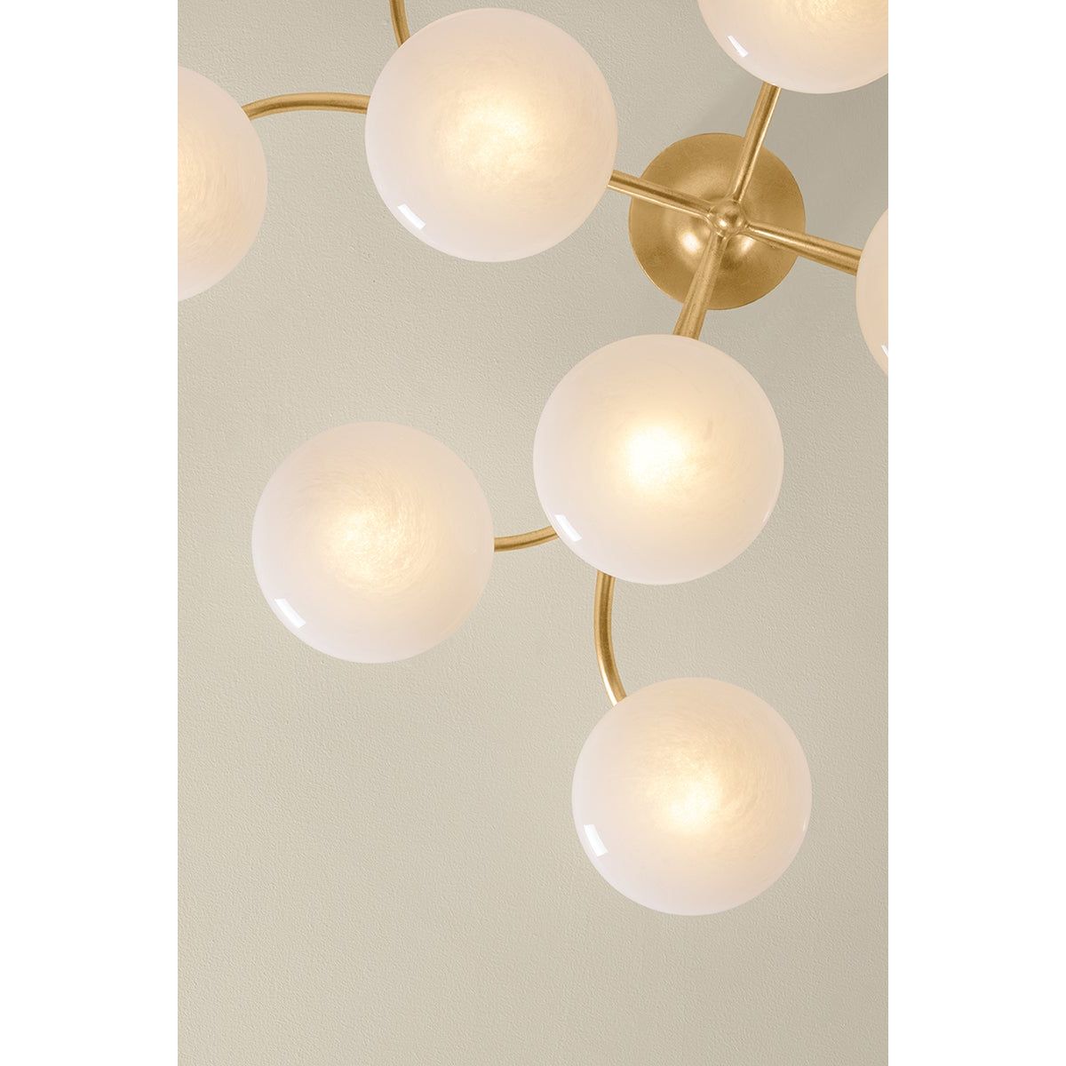 Overhead view of Bayberry chandelier with round illuminated white glass globes on gold brass arms