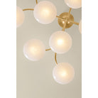 Overhead view of Bayberry chandelier with round illuminated white glass globes on gold brass arms