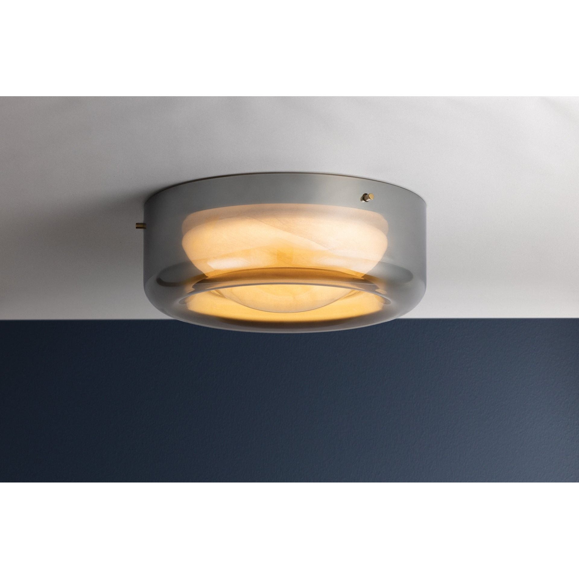 Gunmetal grey round flush mount ceiling light illuminated, showing warm amber glow through diffuser