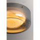 Close-up detail of round flush mount ceiling light showing layered amber glass diffuser disc in gunmetal grey frame