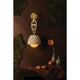 Piasu woven rattan wall sconce styled against dark brown wall with moss, decorative vase and florals