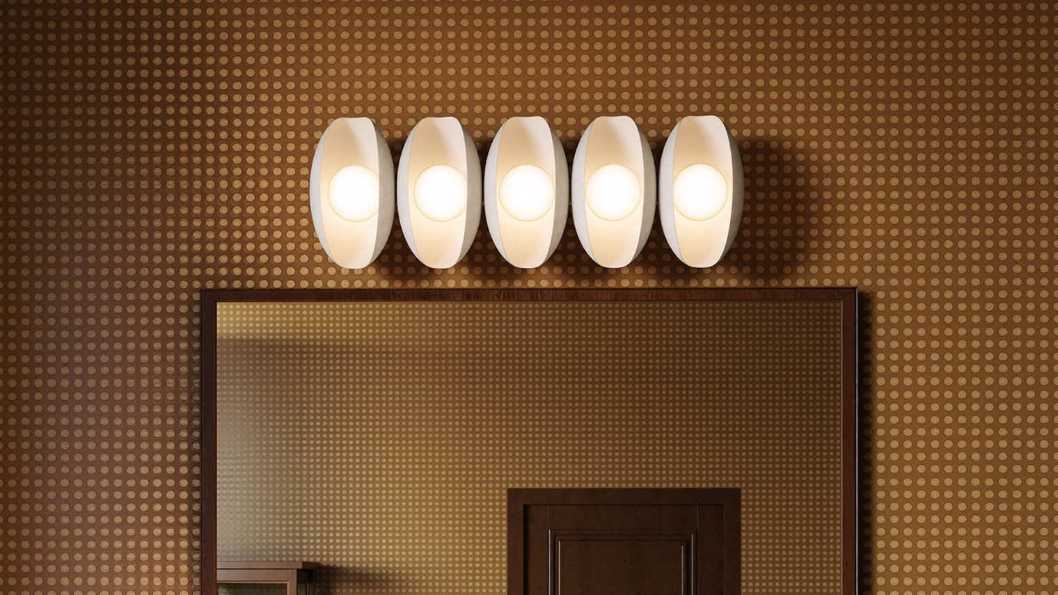 Five-globe white ceramic oval vanity light bar with frosted opal bulbs above mirror on retro gold dot-pattern wallpaper