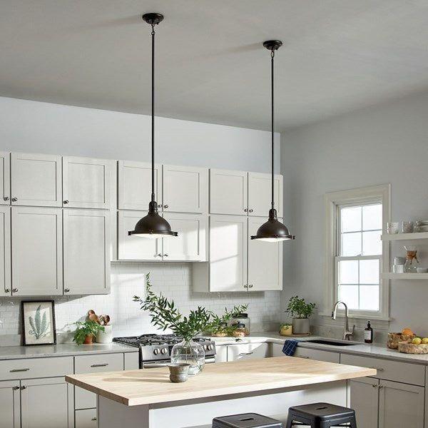 Hatteras Bay pendant light with industrial metal dome shade in bronze finish, shown in a modern kitchen setting.
